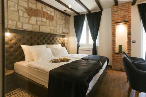 a bedroom with a large bed and a chair at Luxury Rooms Dino in Split