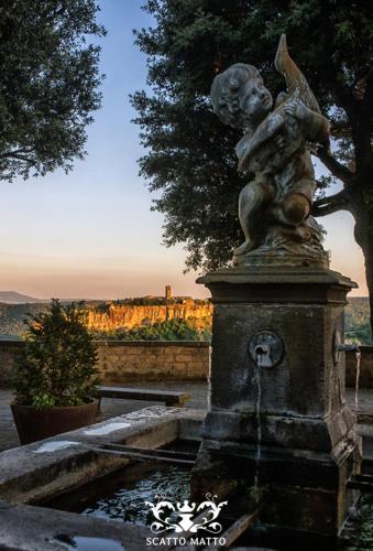 a statue of a little boy sitting on top of a fountain at Hotel Italia & Lombardi in Montefiascone