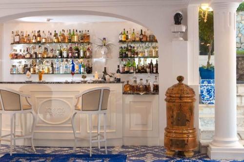 eine Bar mit 2 Stühlen und einer Theke mit Getränken in der Unterkunft Casa Morgano in Capri