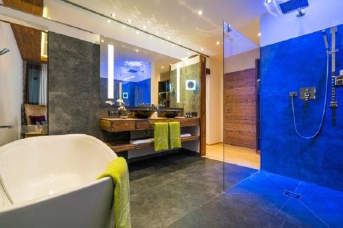 duża łazienka z wanną i prysznicem w obiekcie Sporthotel Cinderella w mieście Obertauern