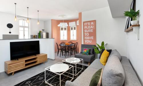 a living room with a couch and a tv at Mr. Katinsky - By TLV2GO in Tel Aviv