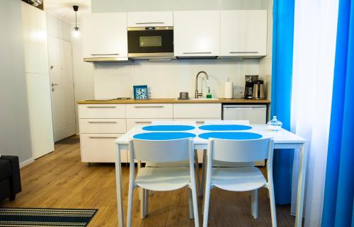 グディニャにあるApartament w Gdyniのキッチン(白いテーブル、白い椅子付)