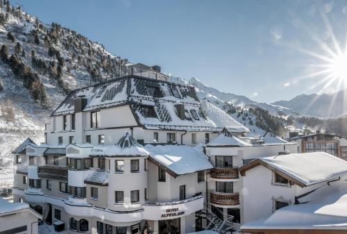 a building covered in snow in front of a mountain at Apartment Alpenland in Obergurgl