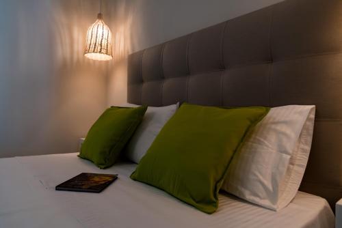 a bedroom with a bed with green and white pillows at Kiperi Exclusive in Parga