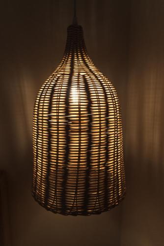 a wicker light fixture hanging from a wall at Kiperi Exclusive in Parga