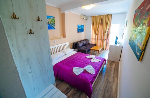 a bedroom with a bed with a purple blanket at Apartments Art in Ulcinj