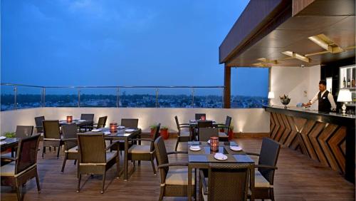 a restaurant with tables and chairs and a bar at Golden Sarovar Portico in Amritsar