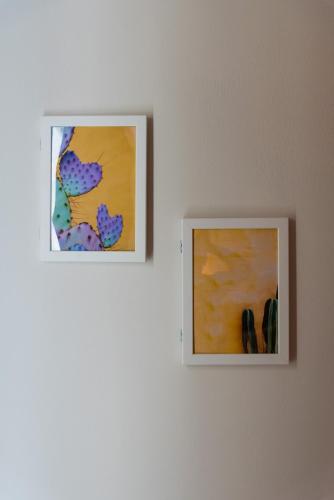 two pieces of art on a white wall at Kiperi Exclusive in Parga