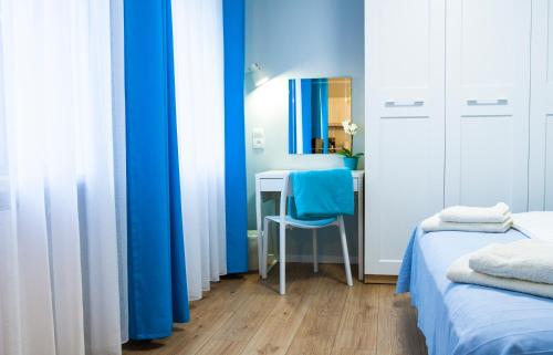 グディニャにあるApartament w Gdyniの青い壁のベッドルーム、デスク(青い椅子付)