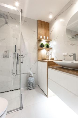 a bathroom with a shower and a toilet and a sink at VIU Indigo Apartments in Gdańsk