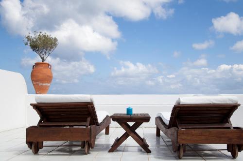 een patio met 2 stoelen, een tafel en een vaas bij Quartara Boutique Hotel in Panarea