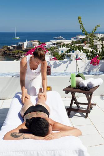 a woman giving a man a massage on a bed at Quartara Boutique Hotel in Panarea
