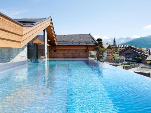 a swimming pool on the side of a building at Hotel Tirol Fiss in Fiss