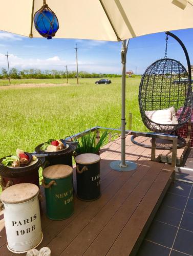 a deck with a chair and a swing and some plants at Zebra Babala B&B in Dongshan