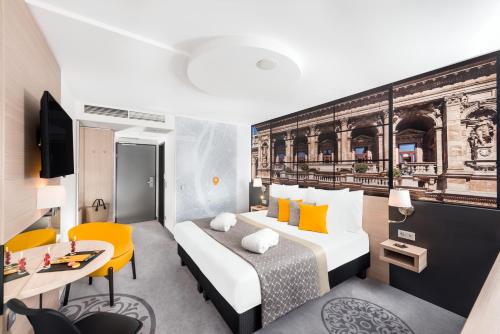 a hotel room with a bed and a desk at Mercure Budapest City Center in Budapest