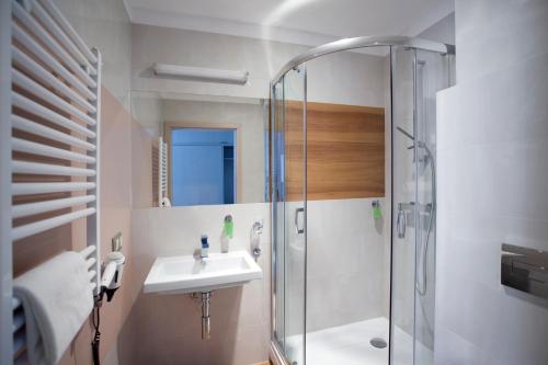 uma casa de banho com um lavatório e um chuveiro em Hotel Kristoff em Łaszków