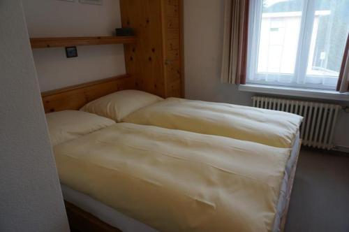 a bedroom with a bed with two pillows and a window at Paradies 210 in Arosa