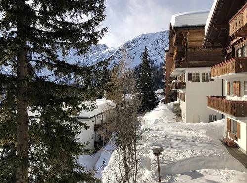 a snow covered street with buildings and a mountain at La Cabana 5 Arosa in Arosa