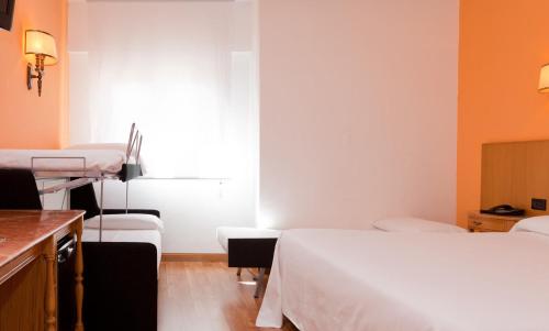 a hospital room with two beds and a window at Gran Hotel Los Angeles in Getafe