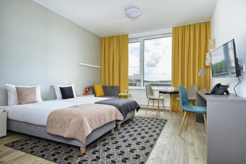 pokój hotelowy z łóżkiem i biurkiem w obiekcie Arche Hotel Poloneza w Warszawie