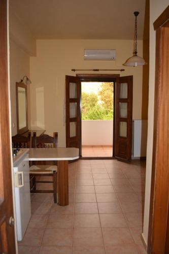 a kitchen with a table and a door to a yard at Ellinospito in Axós