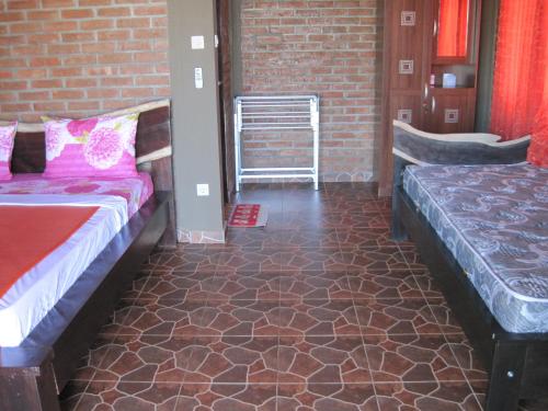 a room with two beds and a brick wall at Gubug Balian Beach Bungalow in Selemadeg