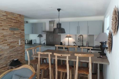 a kitchen with a wooden table and some chairs at Spacious and stylish flat at the foot of the Mont-Blanc ideal for ski in ski out in Les Houches