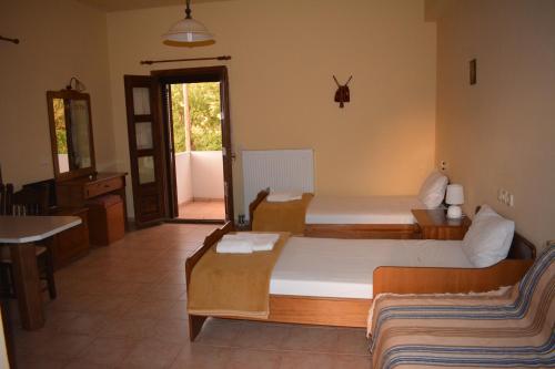 a bedroom with two beds and a living room at Ellinospito in Axós