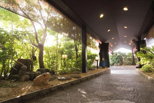 a building with trees and statues in a garden at Ryokan Oomuraya in Ureshino
