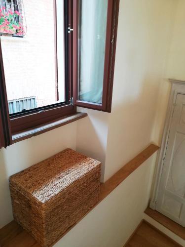 a wicker stool sitting under a window in a room at Raviola e Tajarin in Verduno