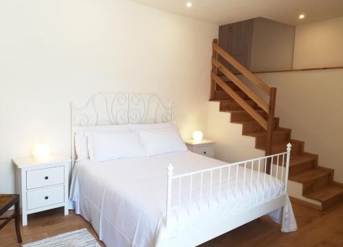 a bedroom with a white bed and a staircase at Raviola e Tajarin in Verduno
