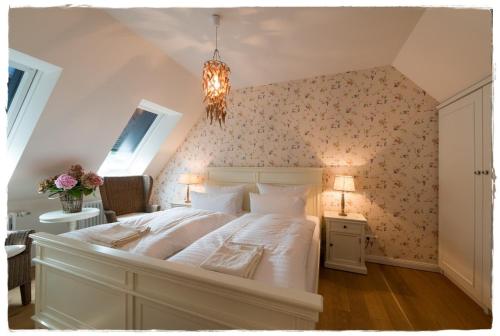 a bedroom with a large white bed with floral wallpaper at Bauernkate Seerose in Rankwitz