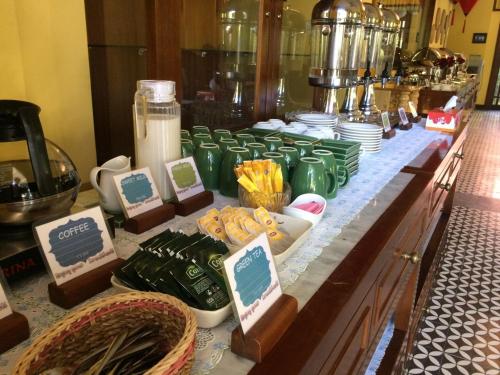 a buffet with green cups and plates on a table at Vinh Hung Old Town Hotel in Hoi An