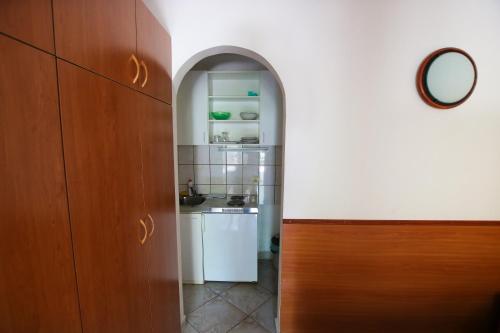 einen Torbogen, der in eine Küche mit einer Spüle führt in der Unterkunft Guest House Saga in Herceg-Novi