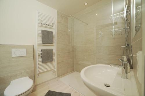 a white bathroom with a sink and a toilet at Bienenhaus in Sassnitz