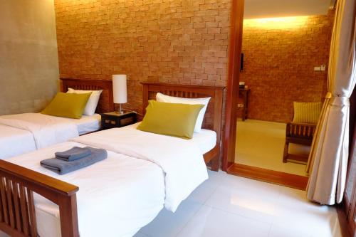 two beds in a room with a mirror at The White Elephant Home in Chiang Mai