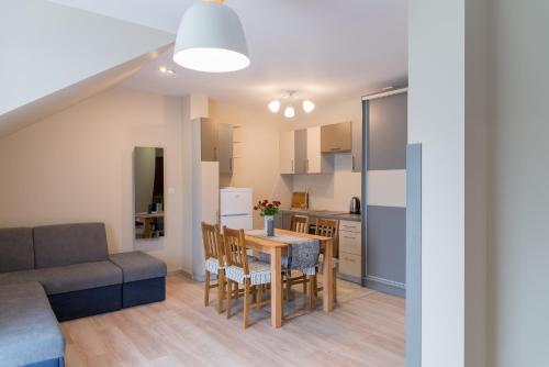 a living room and kitchen with a table and a couch at Apartamenty Koba in Ustroń