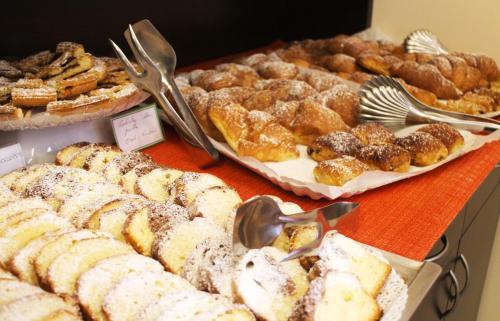 a table with different types of pastries and pies at Hotel Cristallo in Lignano Sabbiadoro