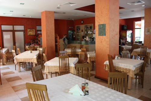 a restaurant with tables and chairs and a person in the background at Family Hotel Gorski Kut in Rilski Manastir