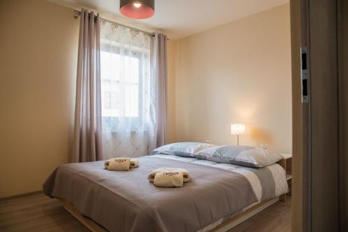 a bedroom with two towels on a bed with a window at Apartamenty Koba in Ustroń
