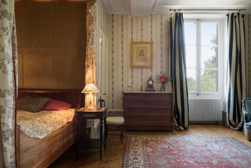 een slaapkamer met een bed, een dressoir en een raam bij Le Rossay in Saint-Clément-de-la-Place