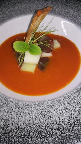 a bowl of soup with cheese and vegetables on a table at BQ Paguera Boutique Hotel - Adults Only in Paguera