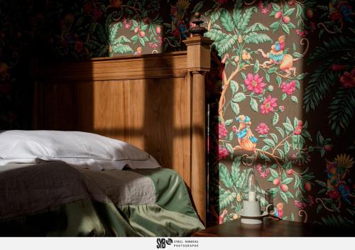 a bedroom with a bed with a floral wallpaper at Le Rossay in Saint-Clément-de-la-Place