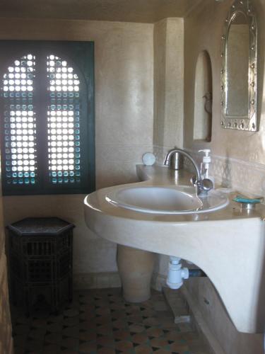 a bathroom with a sink and a mirror at Dar Al Bahar in Essaouira