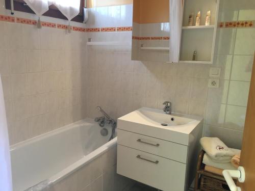 a bathroom with a sink and a bath tub and a sink at Les Loges du Lac - Appartement avec Terrasse in Gérardmer