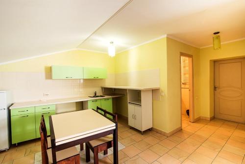 a kitchen with green cabinets and a table in it at Inter Hotel in Ternopilʼ