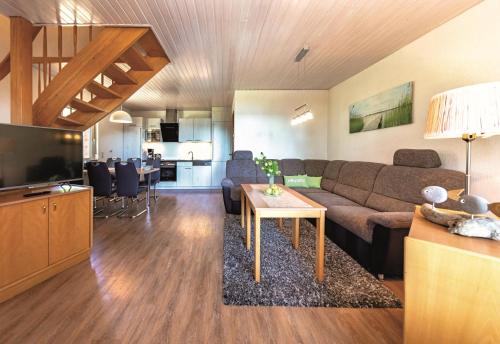 a living room with a couch and a table and a kitchen at Ferienpark Heidenholz in Plau am See