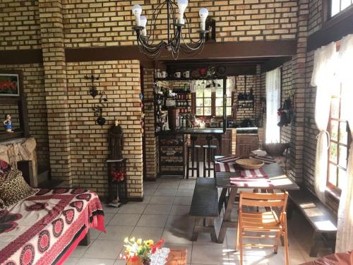 a brick room with a bed and a table and chairs at Casa de Campo in Nova Friburgo