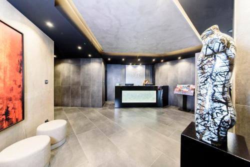 a large room with a desk and a lobby with a sculpture at Just Hotel Milano in Milan