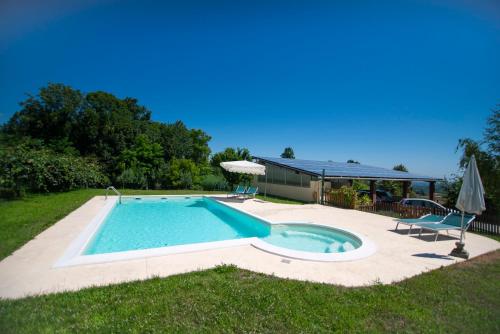 a swimming pool in a yard next to a house at Agriturismo Turina in Bricherasio